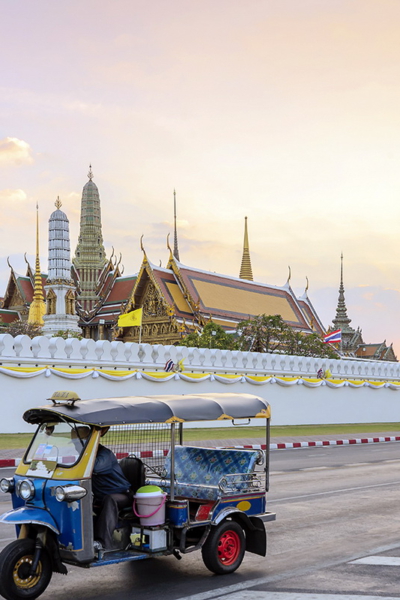 Grand palace and Wat phra keaw at sunset bangkok, Thailand Grand palace and Wat phra keaw at sunset bangkok, Thailand. Blue Tuk Tuk, Thai traditional taxi is the front scene.